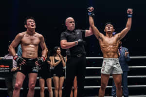 MMA拳手在裁判宣布他為勝者後高舉雙臂慶祝勝利。 — AMOLED 壁紙