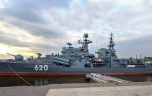 灰色戰艦編號620停泊在碼頭，天空多雲