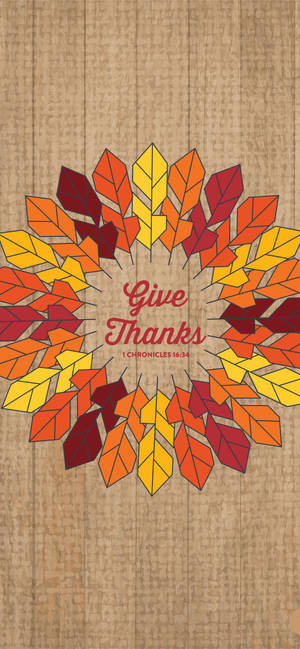 秋葉圓形花環，帶有文字「Give Thanks」和聖經經文歷代志上16:34，背景為木材。