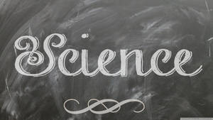 優雅嘅白色粉筆字體喺深灰色黑板上拼出Science，帶有裝飾性旋渦。 — 科學 壁紙