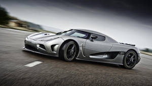 銀色Koenigsegg Agera喺路上高速行駛，帶有動態模糊效果。 — 酷車 壁紙