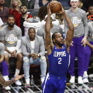 籃球運動員在比賽中身穿藍色快艇隊球衣跳投。