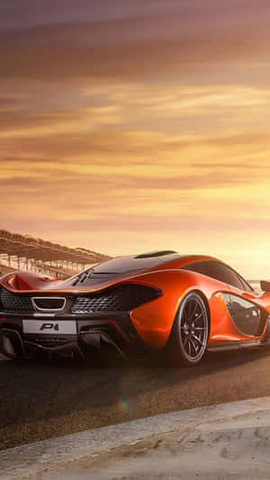 橙色McLaren P1跑車在金色日落下的賽道。