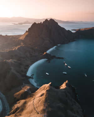 日落時分，從高空俯瞰一個海灣，有船隻，周圍是崎嶇的懸崖。 — 島嶼 壁紙