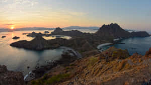 夕陽映照火山島，碧綠海水與蜿蜒海岸線。 — 島嶼 壁紙