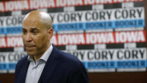 政治家Cory Booker在競選活動中，身後有重複的標語牌。