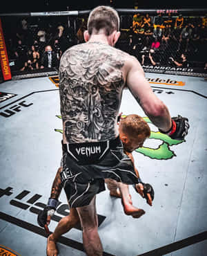 背部有紋身的MMA拳手在UFC八角籠中舉起對手。