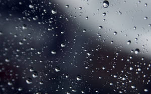 玻璃上雨滴的特寫，背景模糊