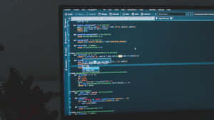 一個人的剪影坐在書桌前，電腦屏幕顯示 Python 代碼。
