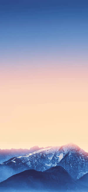 被藍色和桃色日出色調籠罩的積雪山脈。 — iPhone 17 壁紙