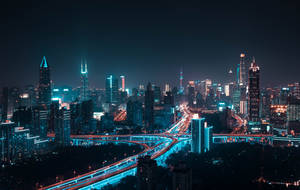 充滿活力的城市夜景，建築物閃閃發光，車輛行駛留下光軌。