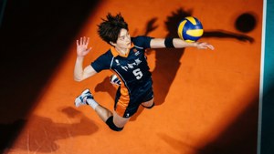 女排球員在半空中扣殺橙色場地上的球