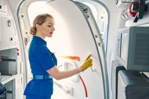 空中服務員用黃色手套清潔飛機門