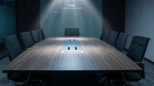 空無一人的現代會議室，聚光燈下有一張長木桌和椅子。
