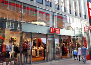 人們走過一間有玻璃櫥窗和人體模型的Uniqlo服裝店。