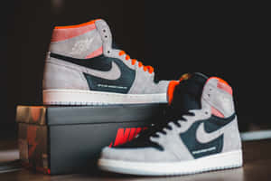 灰黑橙色的 Air Jordan 1 運動鞋放在 Nike 鞋盒上。