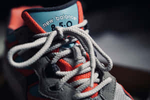 New Balance 850 運動鞋特寫，灰色鞋帶，紅藍色點綴。