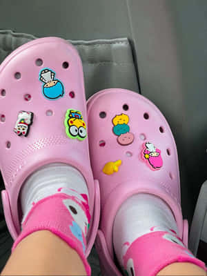 粉紅色Crocs鞋，帶卡通吊飾和相配襪子，在汽車座椅上。