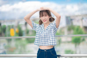 身穿格仔恤衫的年輕女性在陽光燦爛的陽台上微笑