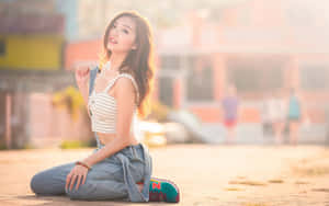 年輕女子在戶外跪著，在金色夕陽中微笑。 — 亞洲 壁紙