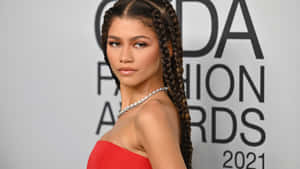 Zendaya 在2021年CFDA時尚大獎上穿著紅色連衣裙和辮子。