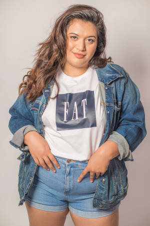 穿著牛仔外套和短褲的女性，T恤上有「FAT」文字。