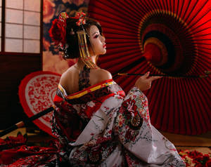 一位穿著傳統日本和服的女人，在攝影棚中手持紅色陽傘。 — 日本 壁紙