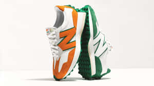 兩雙色彩繽紛的 New Balance 運動鞋，帶有橙色、綠色和白色點綴，直立於白色表面上。