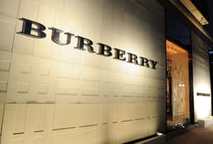 夜間 Burberry 商店外牆，帶有發光標誌和帶紋理的牆板。