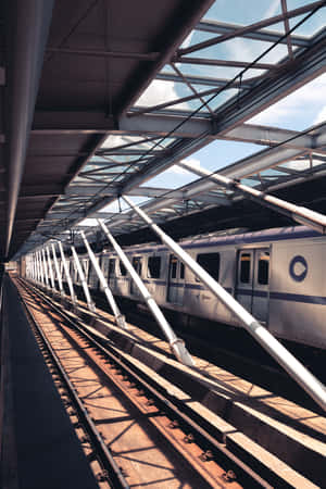 高架車站玻璃屋頂下的銀色列車，陽光投下陰影