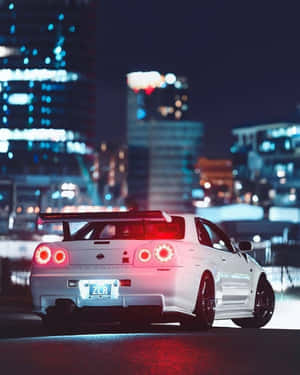 夜晚潮濕城市街道上的白色日產Skyline R34跑車，帶有發光的紅色尾燈。
