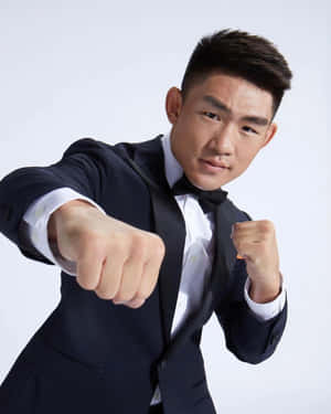 穿禮服嘅男士擺出拳擊姿勢，雙手握拳