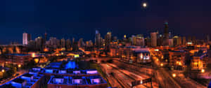 夜晚的城市天際線，明亮的月亮和閃爍的燈光。