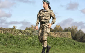身穿迷彩制服的女兵在戶外草地上行走。 — 軍事動圖 壁紙