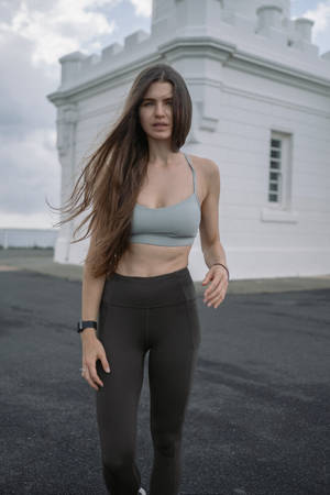 穿著運動服的女士在白色建築附近行走。