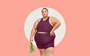 穿著運動服的大碼女性在工作室拍攝中手持乾燥草本植物。