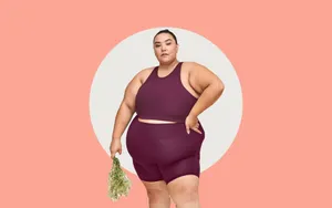 穿著運動服的大碼女性在工作室拍攝中手持乾燥草本植物。