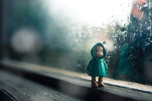 下雨時窗台上穿著青綠色雨衣的小人偶 — 可愛桌面動態圖 壁紙