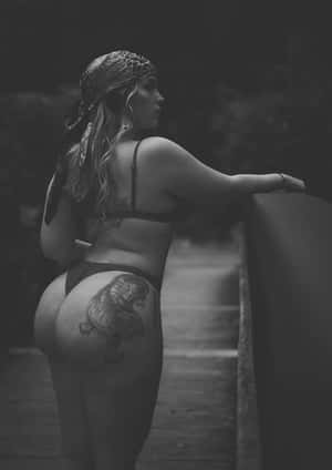 一位臀部有老虎紋身的女性，戴著頭巾站在木橋上。 — 模特兒 GIF 壁紙