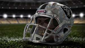 Raiders 美式足球頭盔，裡面有頭骨，在草地上。