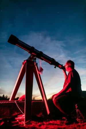 在星空下夜晚使用望遠鏡的人，帶有紅色燈光。 — 夜空 壁紙