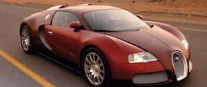 紅色Bugatti Veyron在日落時分於沙漠公路上飛馳。 — 2560x1080 壁紙