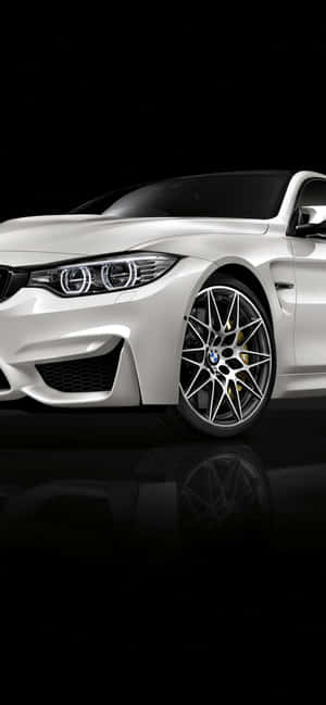 白色BMW跑車，帶金色制動卡鉗，置於黑色反光表面。