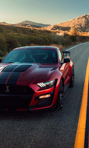 紅色Shelby Mustang GT500在日落時分的山路上