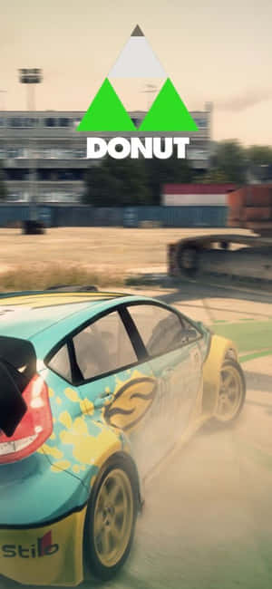 拉力賽車在泥地賽道上飄移，上方有DONUT標誌 — Pixel 7 壁紙