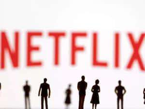 剪影微型人物面向一個大型模糊的Netflix標誌。