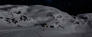 星空下溫暖發光且有腳印的積雪山洞