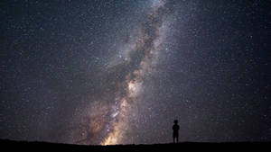一個人獨自站在星空下，銀河系清晰可見。