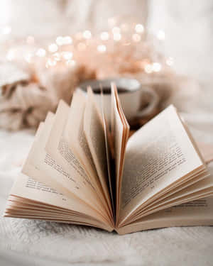 打開的書、杯子和仙女燈，營造舒適的閱讀氛圍。