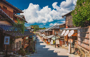 傳統日本街道，有木建築和紙傘，在晴朗的天空下。 — 日本 壁紙